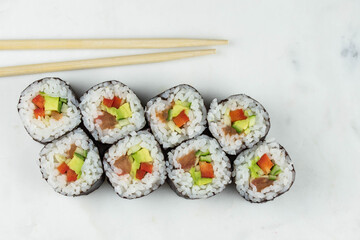 Sushi rolls prepared by professional asian chef with traditional Japanese ingredients. Salmon, rice, vegetables, sesame seeds. 