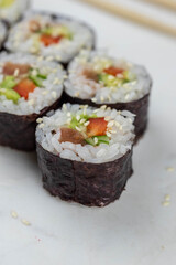 Sushi rolls prepared by professional asian chef with traditional Japanese ingredients. Salmon, rice, vegetables, sesame seeds. 