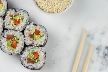 Sushi rolls prepared by professional asian chef with traditional Japanese ingredients. Salmon, rice, vegetables, sesame seeds. 