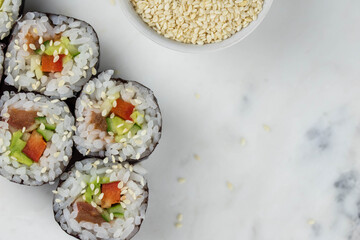 Sushi rolls prepared by professional asian chef with traditional Japanese ingredients. Salmon, rice, vegetables, sesame seeds. 