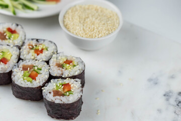 Sushi rolls prepared by professional asian chef with traditional Japanese ingredients. Salmon, rice, vegetables, sesame seeds. Sushi cooking and making concept