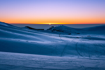 tramonto sulla piana di campocatino innevato. vista sugli impianti sciistici, tracce nella neve