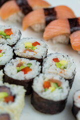 Sushi rolls prepared by professional asian chef with traditional Japanese ingredients. Salmon, rice, vegetables, sesame seeds. 