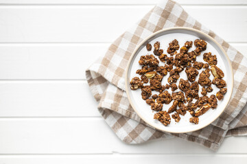 Chocolate breakfast cereal. Morning granola with milk in bowl.