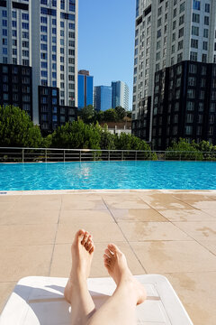 Bare feet of a woman sunbathing at the swimming pool