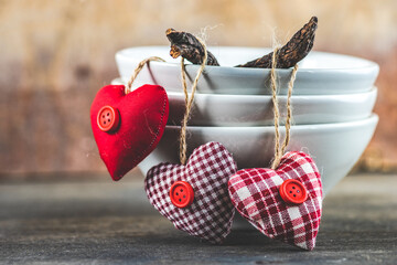 Red textile hearts hanging over the edge of  bowls
