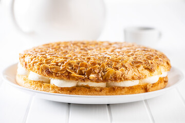  Sweet almond cake. Pie with cream and almonds on white table.