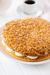  Sweet almond cake. Pie with cream and almonds on white table.