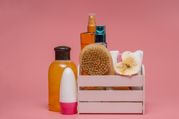 Flat lay composition with spa cosmetics and towel on pink background
