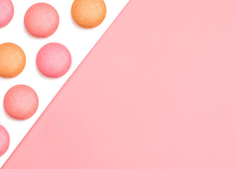 Mini cakes Flat lay photo with copy space Pink and orange macaroons on two-tone background