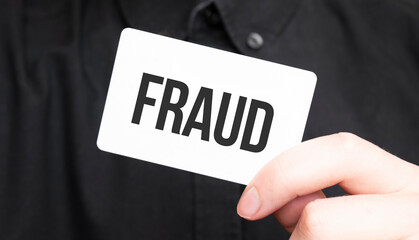 Businessman holding a card with text FRAUD,business concept