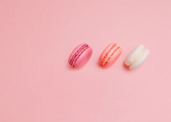 French biscuits Top view photo in minimal style White, pink and orange macaroons on pink backdrop Template with copy space