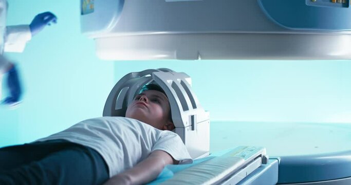 Crop doctor in gloves starting MRI scanning of kid