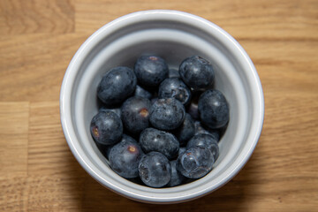 A bowl of delicious blueberries in a white bowl