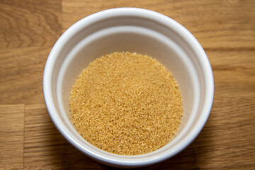 A bowl of brown sugar on a kitchen table