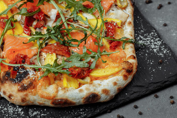 Delicious pizza with salmon and vegetables. italian pizza