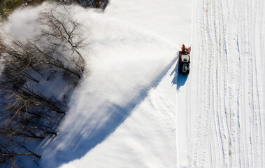 Snow thrower is cleaning the snow. Bird’s eye view.