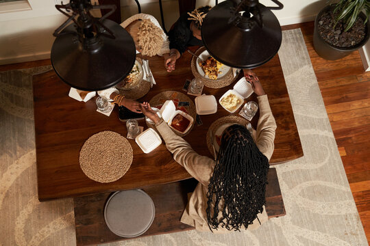 Black female friends praying blessing food, togetherness