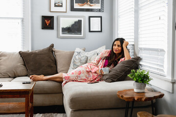 Indian woman cozy on couch at home