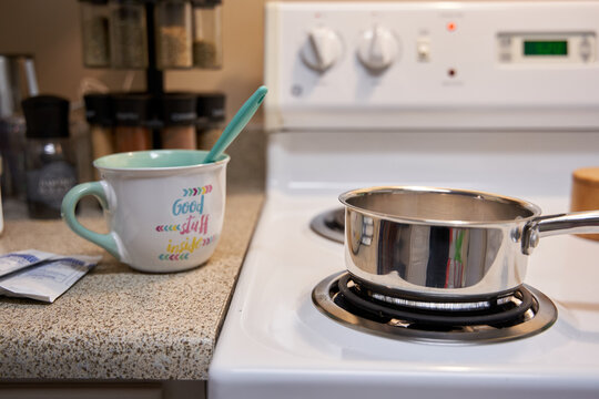 Middle class family home kitchen stovetop, pot and coffee mug for hot chocolate