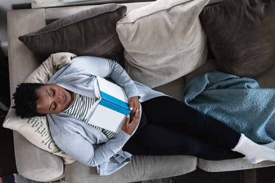 Black woman relaxed on couch at home, comfortable,sleep