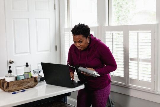 Black woman watching online tutorial for home improvement, DIY