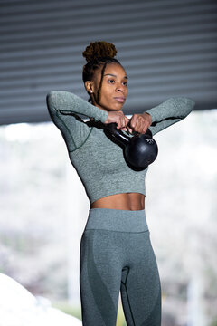 Black woman does fitness workout, kettlebell upright row