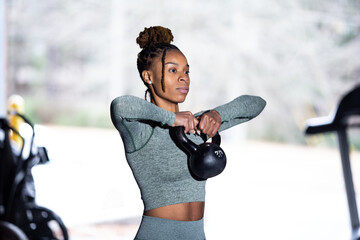 Black woman does fitness workout, kettlebell upright row
