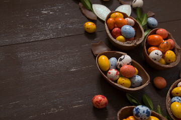 Easter eggs hunt concept with chocolate eggs on wooden background copy space