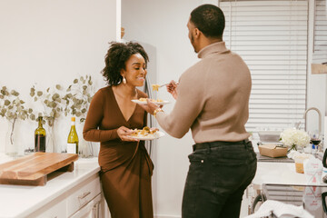Young couple eats takeout at home in kitchen, date night at home