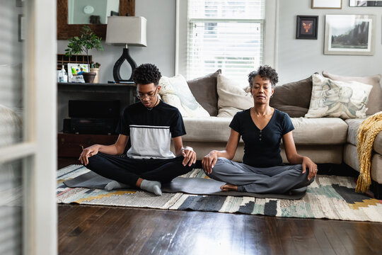 Black mother and son doing meditation and breathing exercises, peaceful, relaxation