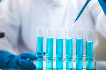 Fototapeta premium Researchers scientist working analysis with blue liquid test tube in the laboratory, chemistry science or medical biology experiment technology, pharmacy development solution