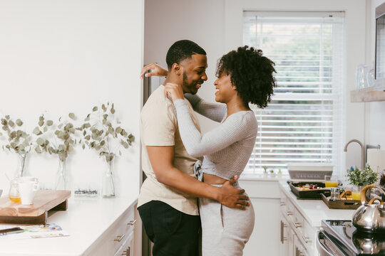 Black couple dancing in kitchen at home, intimate moment