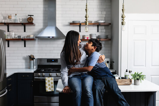 Indian Mother And Son Embracing On Kitchen Counter, Family Loving Moment