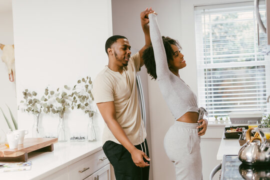 Black couple dancing in kitchen at home, intimate moment