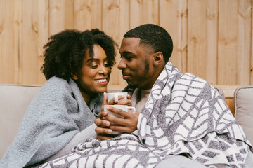 Couple snuggled under blankets, cozy and warm