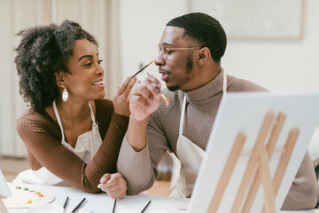 Black couple has fun painting and laughing during date night, paint and craft DIY
