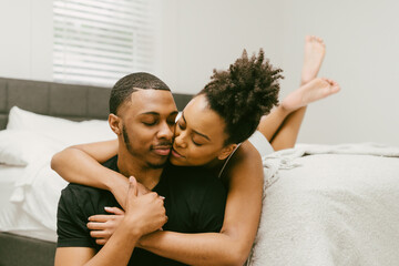 Beautiful Black couple embrace in bed at home, young love