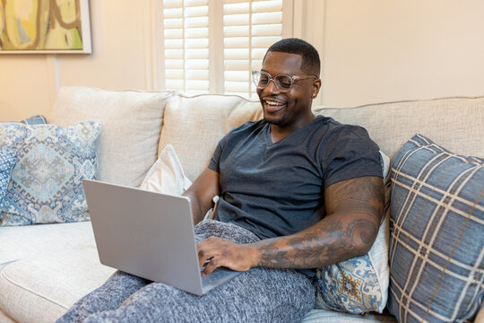 African American Man Working From Home On Laptop In Living Room, Video Chat Conference Call