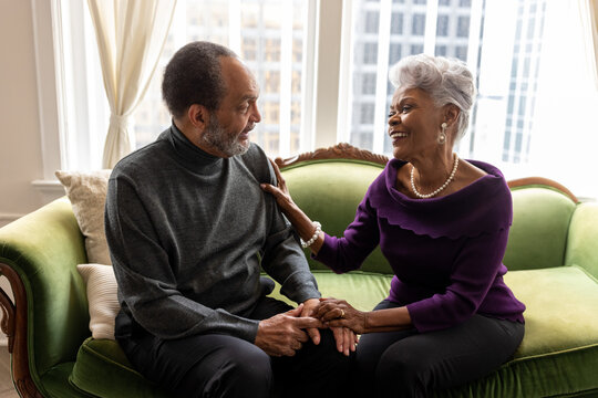 Senior couple connecting and talking at home on couch