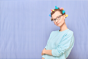 Portrait of happy cute girl with bright colorful hair curlers on head