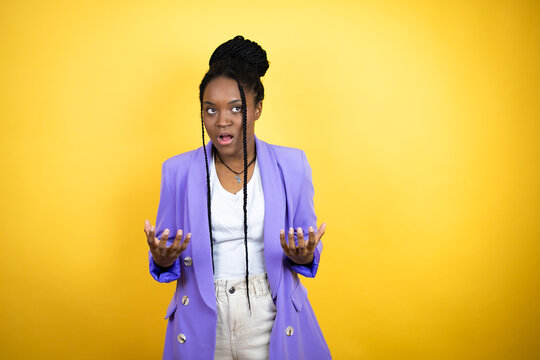 Young african american business woman crazy and mad shouting and yelling with aggressive expression and arms raised. Frustration concept.