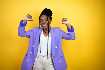 Young african american business woman looking confident with smile on face, pointing oneself with...
