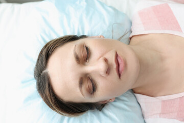 Portrait of woman with closed eyes lying in bed