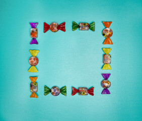 Fototapeta premium Candy frame on green background, top view. 