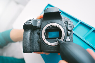 Close up of cleaning camera sensor with dust cleaner, air blower or vacuum pump. Photography...
