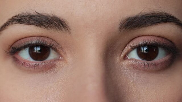 Close up. Macro zoom shot of eyes. Slow motion. Attractive brunette girl look at the windows. Caucasian beautiful female face. Young woman eyes opening while looking at Camera, having long Eyelashes.