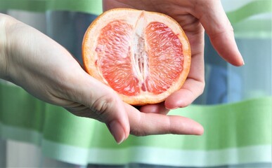 hand holding juicy grapefruit. citrus