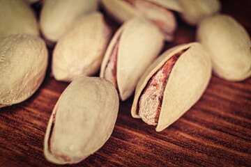A lot of Pistachio in shell on a wooden cutting board macro image with copyspace