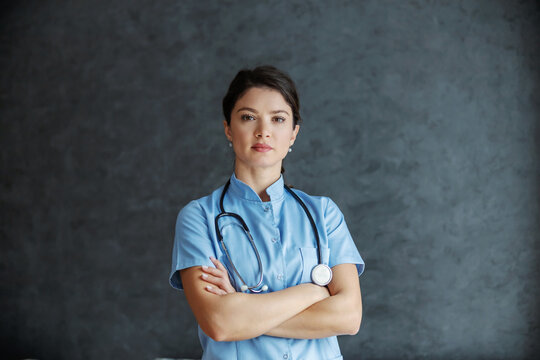 Serious female doctor with stethoscope around neck standing with arms crossed. She is dedicated and experienced doctor.